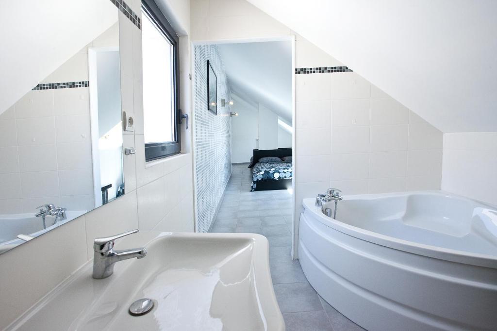 格勒诺布尔帕特里夏公寓酒店的白色的浴室设有浴缸和水槽。