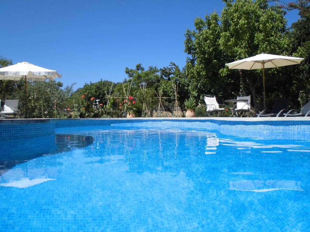 阿尔塔Agroturismo Na Set Centes - Adults Only的一个带椅子和遮阳伞的大型蓝色游泳池