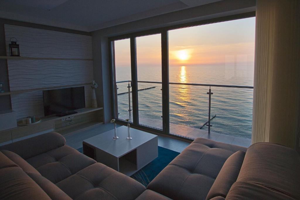 尤斯托尼莫斯基纳克利夫耶公寓的带沙发的客厅,享有海景