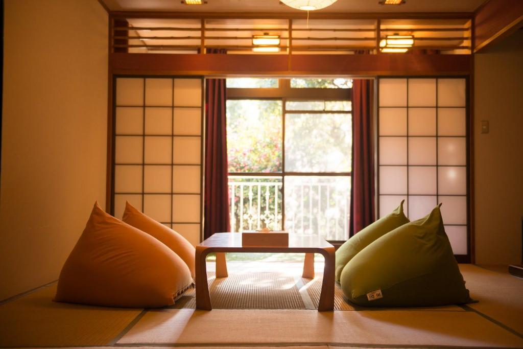 汤河原町和京日式酒店的窗户前设有桌子的房间