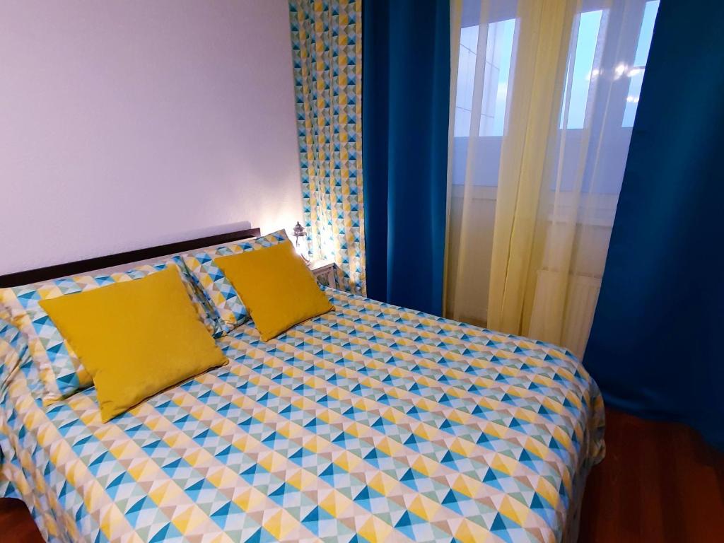 沃罗涅什flat-all 246 Morskoy однокомнатная квартира до 6 мест с подземным паркингом рядом с ТРЦ Галерея Чижова в ЖК Атлант的一间卧室配有一张带两个黄色枕头的床