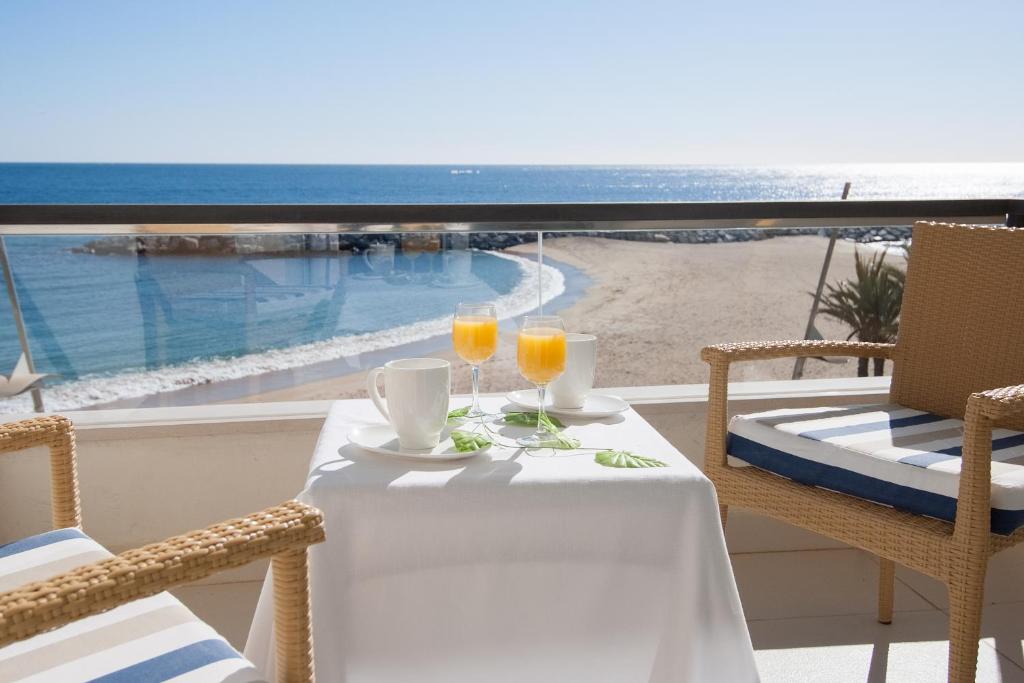 圣安东尼奥·德·卡隆罗萨马尔酒店的阳台上的桌子上放着两杯橙汁