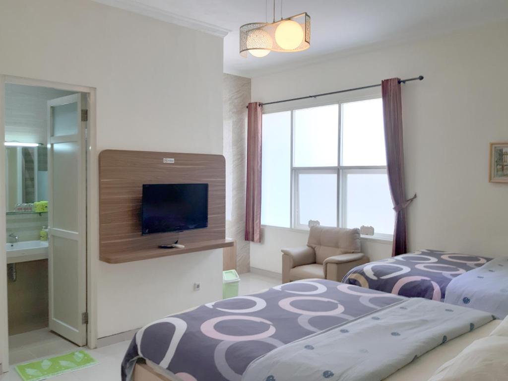 泗水留芳頌生活酒店的酒店客房设有两张床和电视。