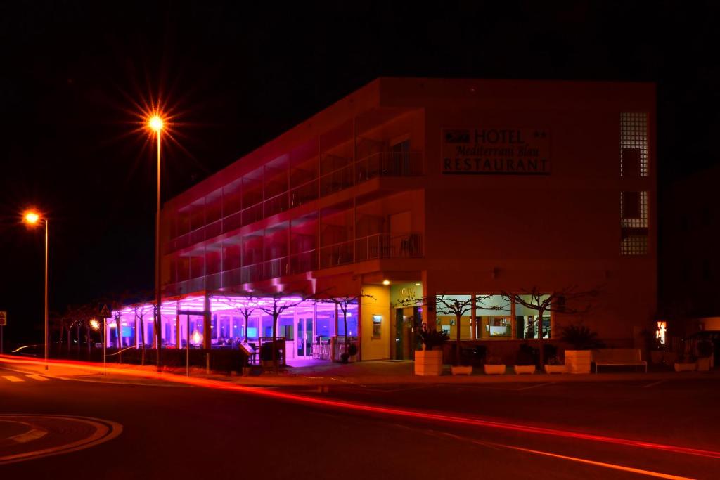 圣海梅-德恩韦哈地中海布劳酒店的一座晚上有紫色灯光的建筑