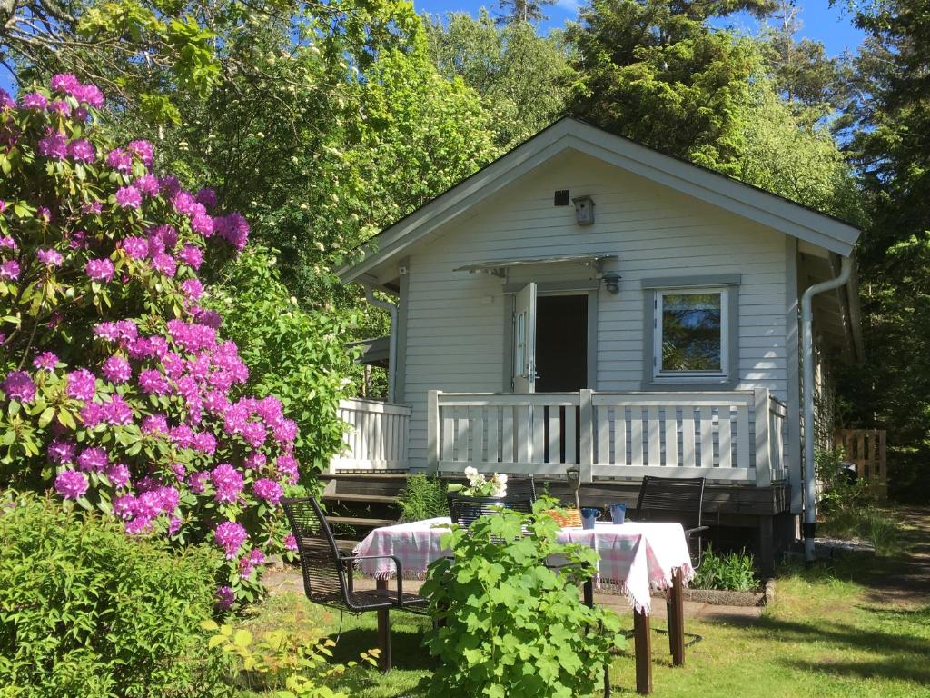 SäbyStuga i naturskönt område på västra Tjörn的一个小房子,带桌子和一些鲜花