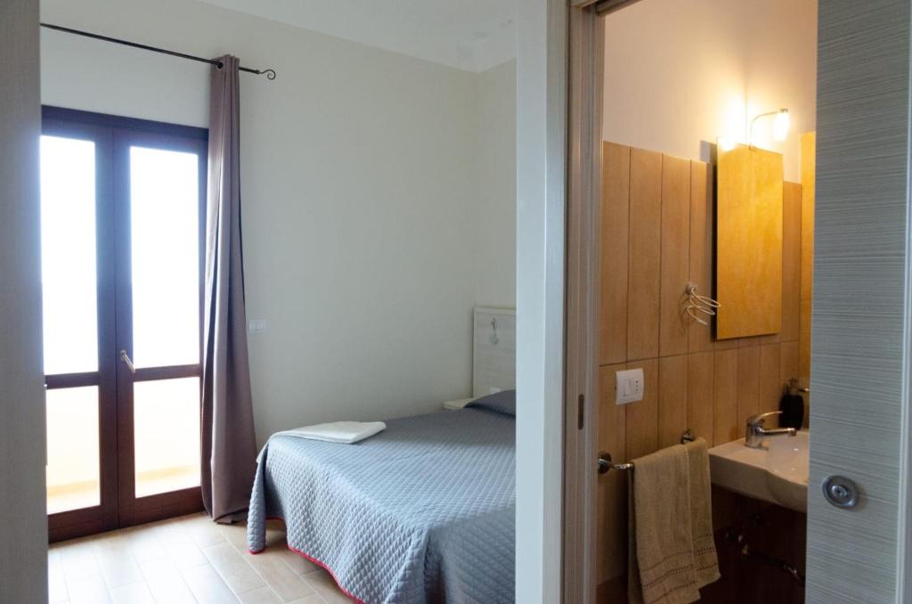 潘泰莱里亚布耶马里诺酒店的一间卧室配有一张床,浴室设有水槽