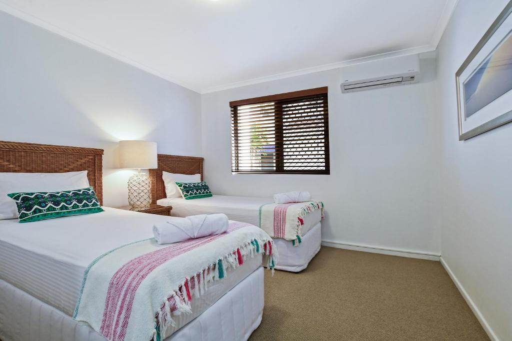 穆卢拉巴海滩港公寓的一间卧室设有两张床和窗户。