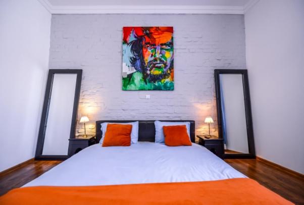 锡吉什瓦拉ATRIUM 22 Apartment的卧室配有一张床,墙上挂有绘画作品