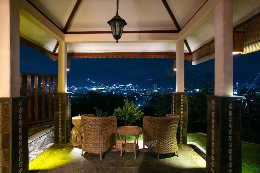 巴图香提度假屋的一个带椅子和桌子的门廊,享有美景