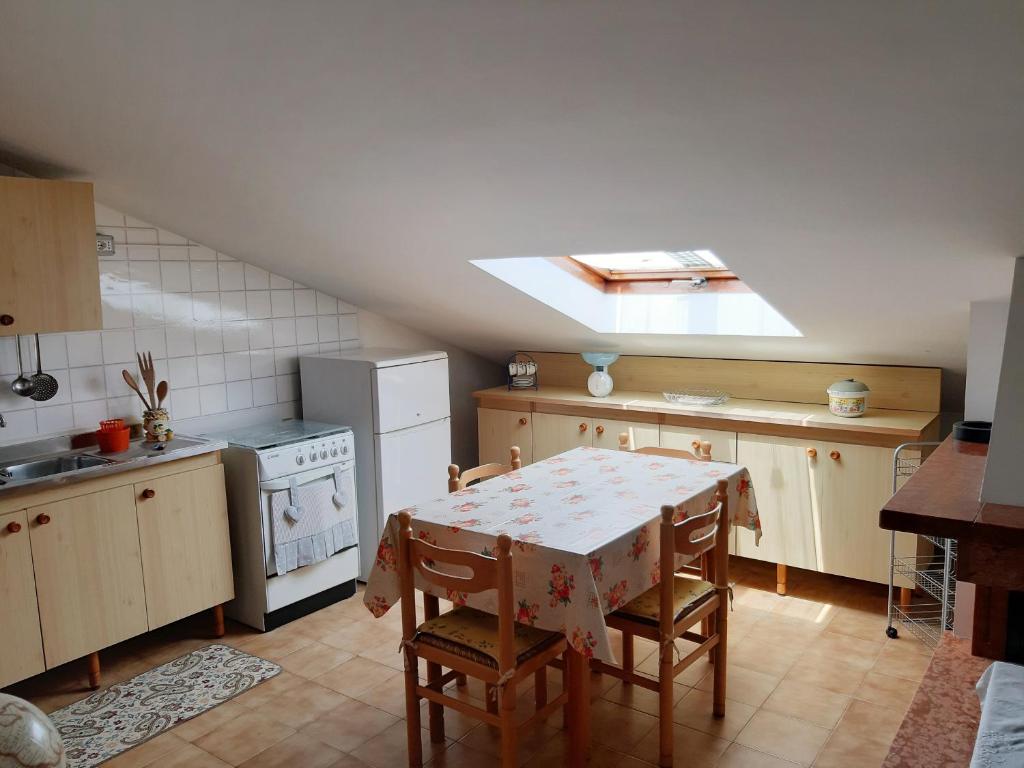 皮内托Una mansarda al mare的厨房配有桌椅和炉灶。