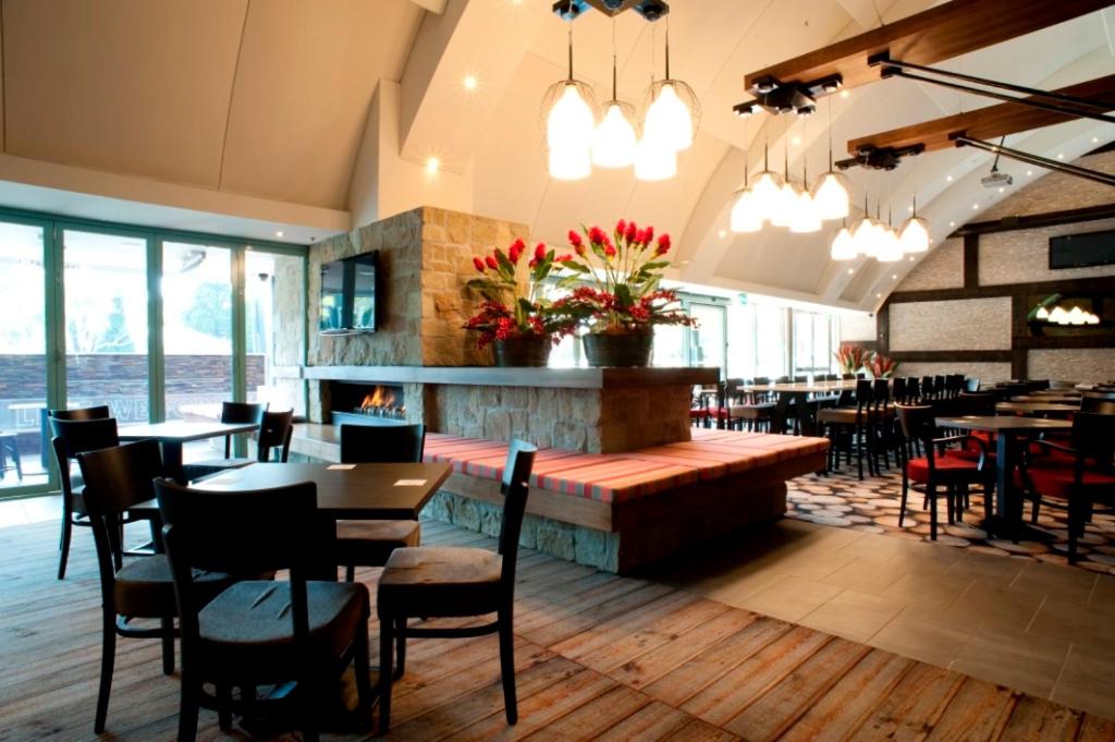 米塔贡Springs Mittagong的一间带桌椅和壁炉的餐厅