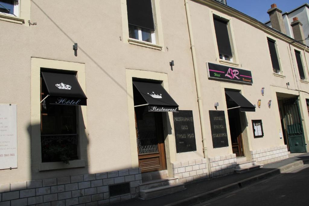 伊苏丹Logis Hôtels Restaurant Les 3 Rois的建筑物一侧有黑色遮阳篷的商店