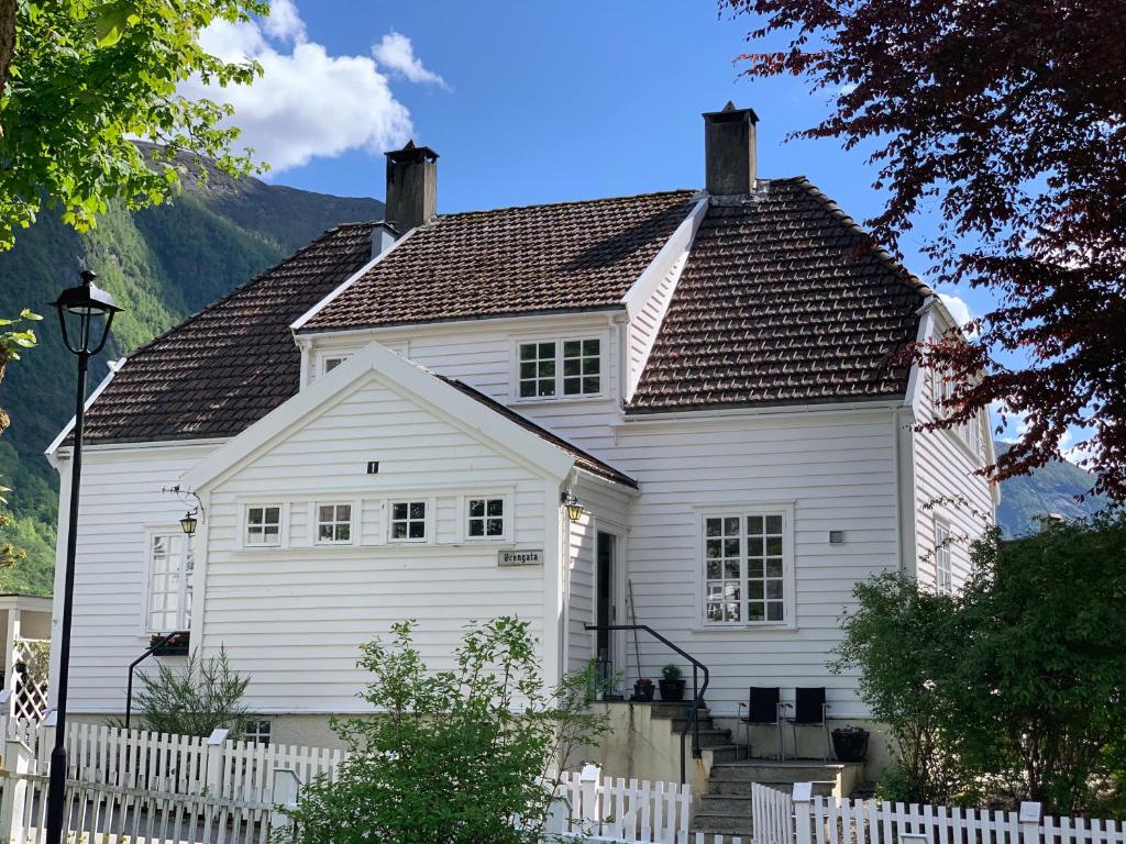 HøyangerHøyanger 3 roms leilighet的前面有栅栏的白色房子