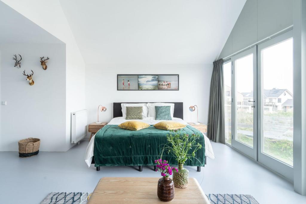 赞德沃特Paulus Loot Zandvoort的白色的卧室设有床和大窗户