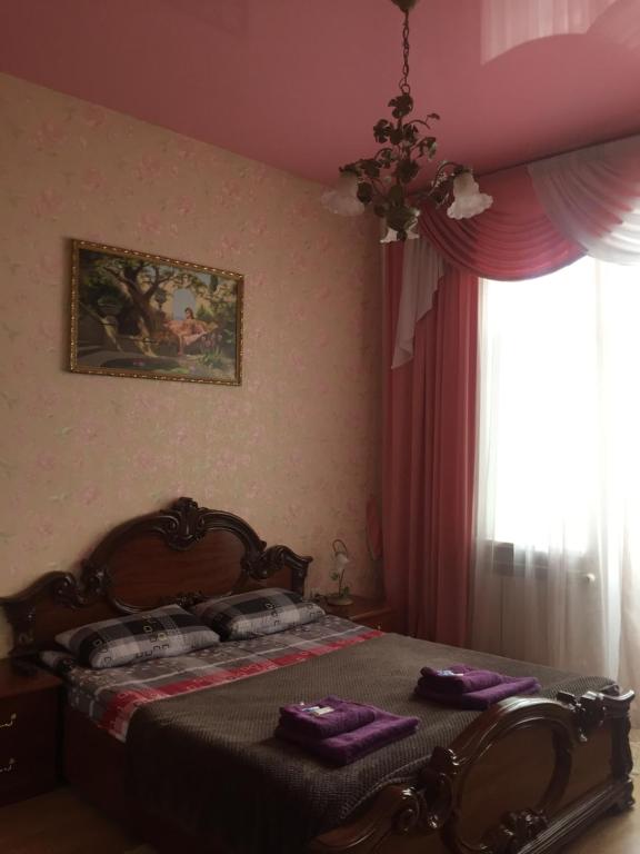 捷尔诺波尔Затишна квартира в центрі міста的一间卧室配有一张带紫色床单的床和窗户。