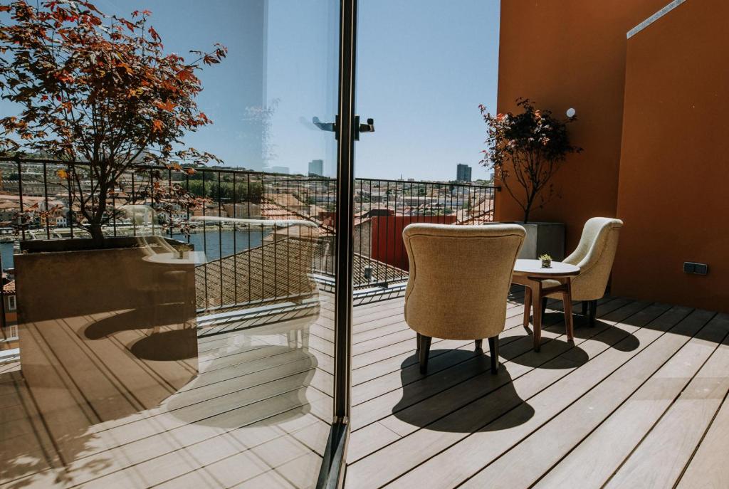 波尔图Exmo Hotel by Olivia的设有一个配有桌椅并享有美景的阳台。