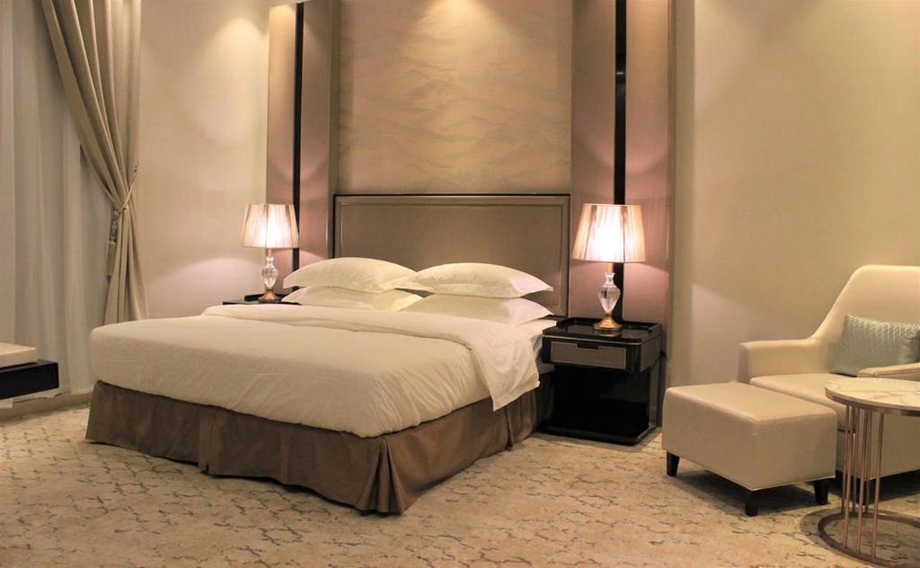 比沙堡Malfa Hotel Apartments的一间卧室配有一张大床和一把椅子