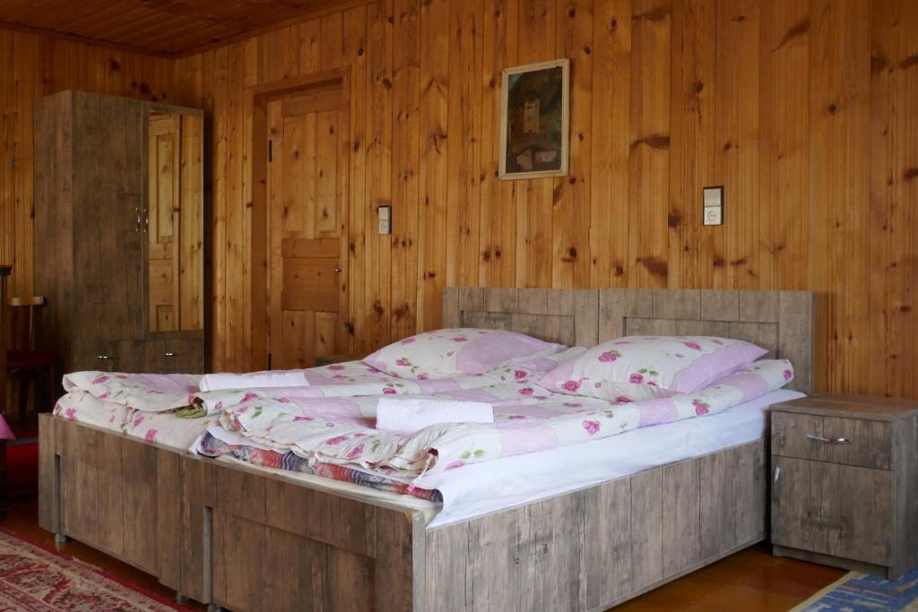 梅斯蒂亚Lagami house的卧室配有一张木墙内的大床