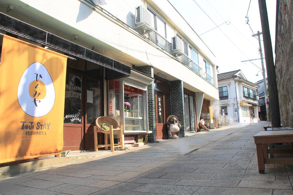 别府Beppu Kannawa Onsen HIROMIYA的建筑物一侧有标志的街道