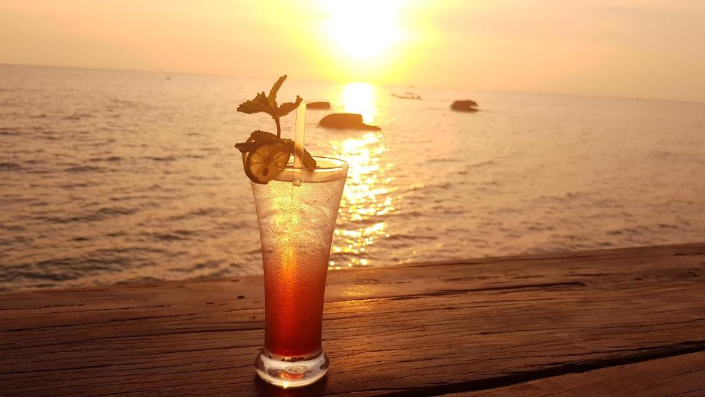 富国自由海滩度假酒店的在海滩上喝一杯,在日落的背景下