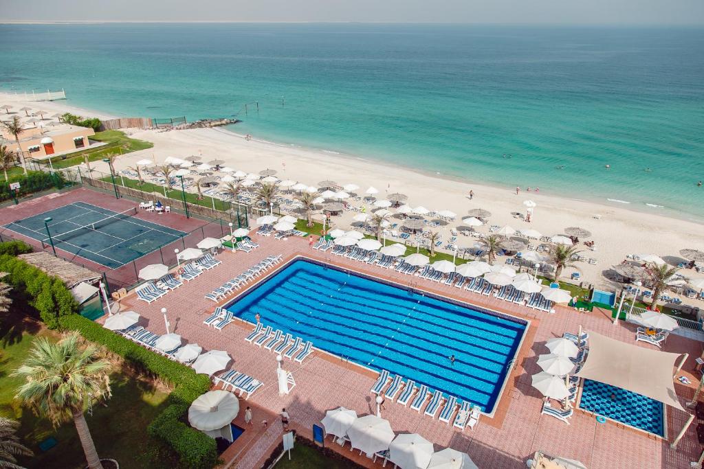 沙迦沙迦卡尔顿酒店的享有游泳池和海滩的上方景色