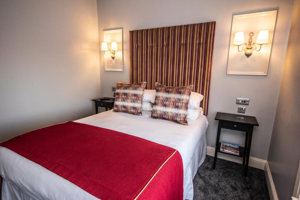 科特布里奇The Georgian hotel的酒店客房设有一张带红色毯子的大床