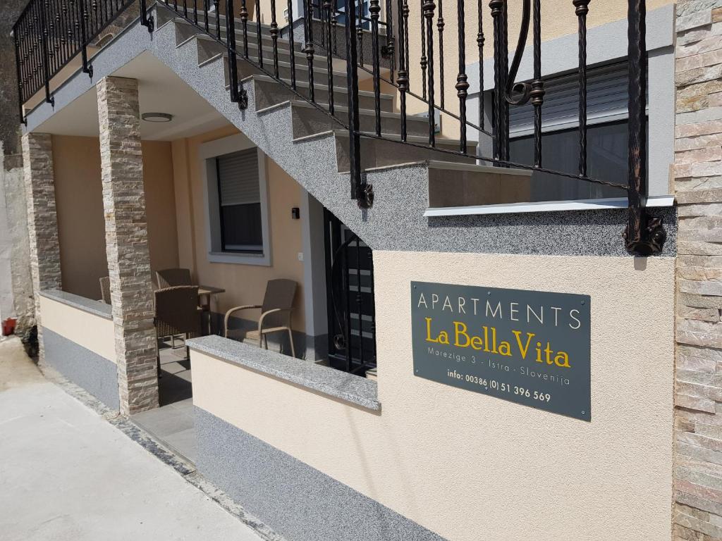科佩尔La Bella Vita Marezige的建筑一侧的一个标志,上面写着读书的la bellevia公寓