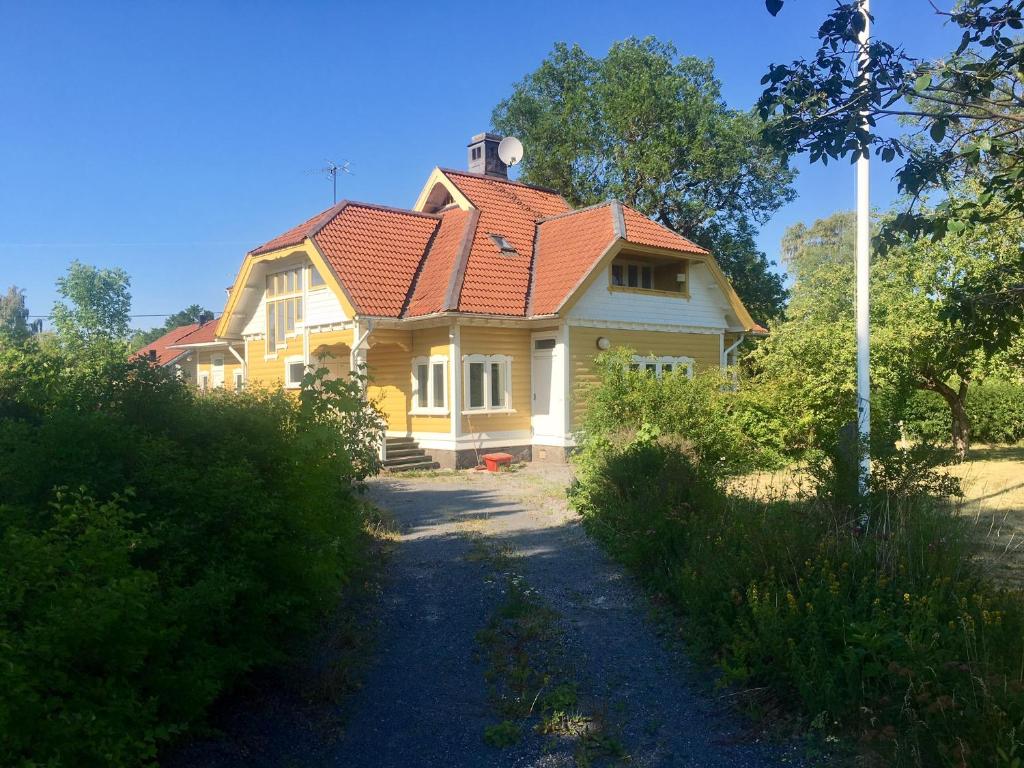 VäddöPensionat Kanalvillan的黄色的房屋,有红色的屋顶