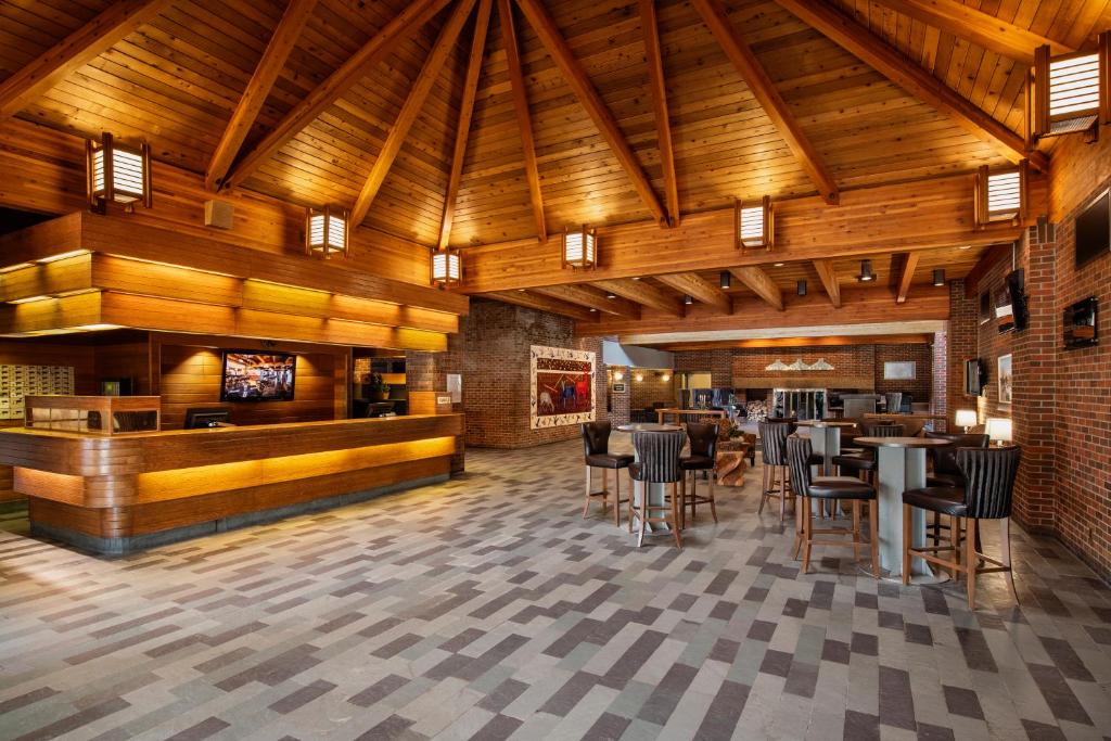 桑德贝Valhalla Hotel & Conference Centre的餐厅设有木制天花板和桌椅