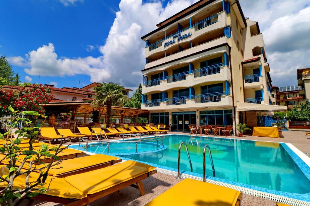 阳光海滩波拉波拉酒店的酒店设有带黄色躺椅的游泳池