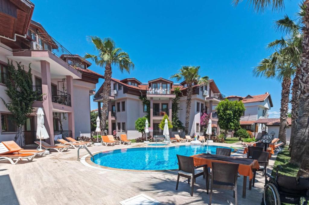 达利安敏挞公寓式酒店的一座别墅,设有游泳池和棕榈树