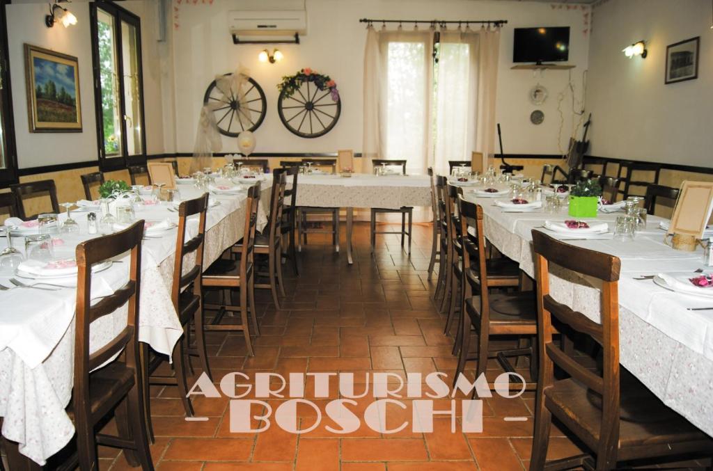 雷吉奥洛Agriturismo Boschi的一间设有白色桌椅的用餐室