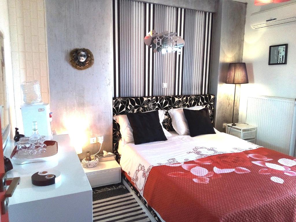 雅典Greek hospitality 2的卧室配有红色和白色的床和书桌。