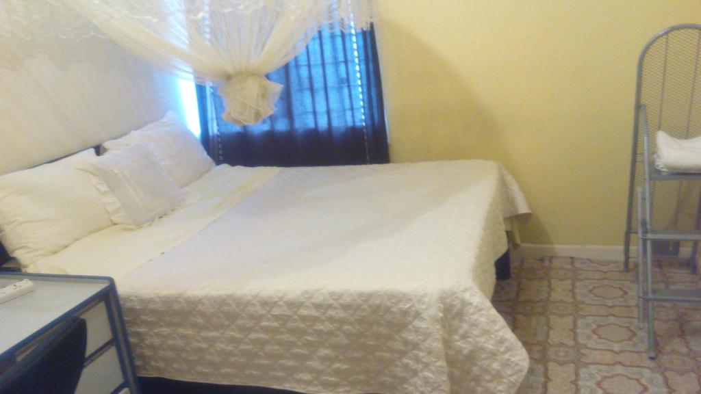 内罗毕Juddy Place的卧室配有白色的床和窗户
