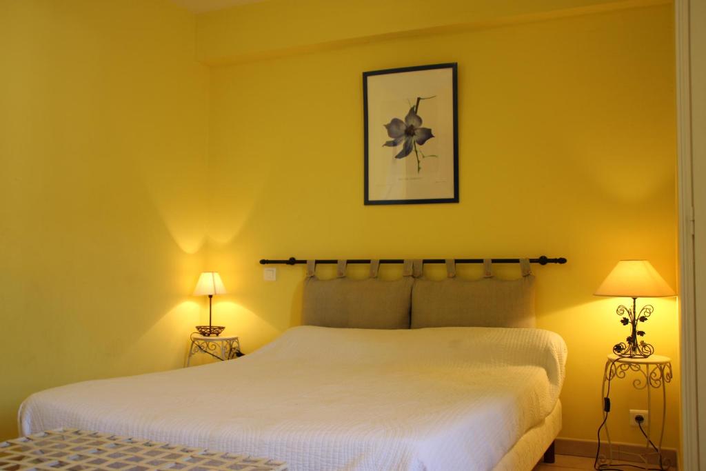 奥普Le Provençal的卧室配有一张白色大床和两盏灯。