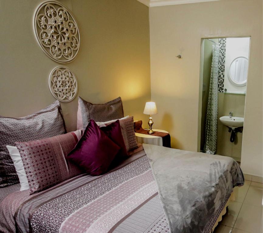 纽卡斯尔Patterson B&B的一间卧室配有一张带紫色枕头和水槽的床。