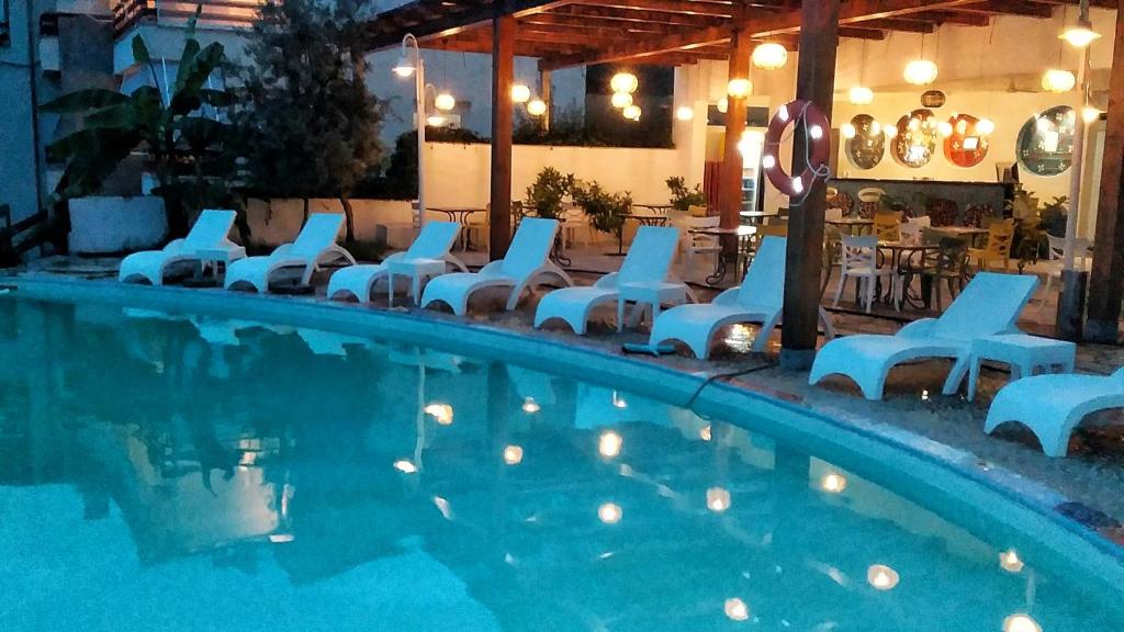 德尔米Olives Residence的一个带白色椅子和一组设施的游泳池
