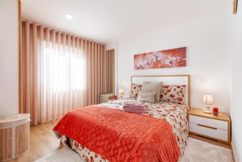 布拉加Avenida apartment 1,2 e 3的一间卧室配有一张带红色毯子的大床
