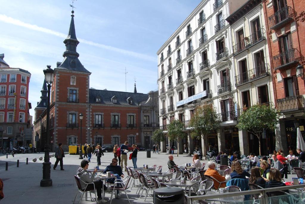 马德里阿斯图里亚珍珠旅馆的一群坐在城市街道桌子上的人