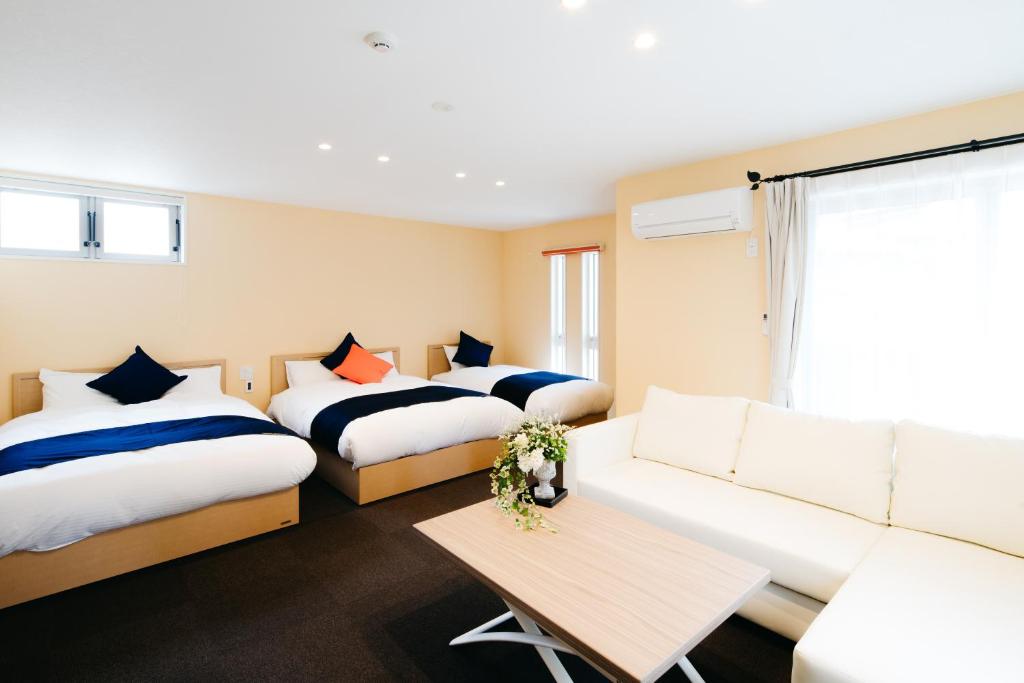北九州FUKUOKA MOJIKO STAY的酒店客房,设有两张床和一张沙发