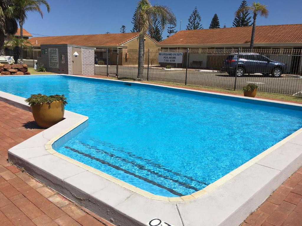 杰拉尔顿Hospitality Geraldton SureStay Collection by Best Western的庭院里的一个蓝色海水游泳池