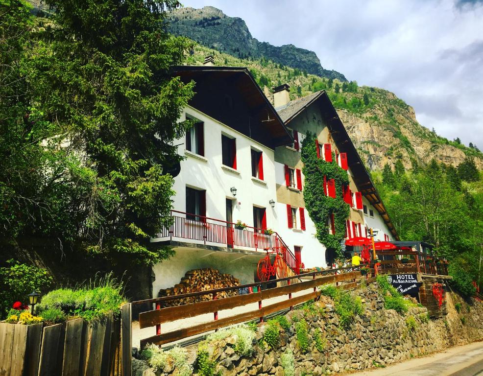 莱德萨阿尔卑斯本艾克尔酒店的山上的白色建筑,有红色的窗户