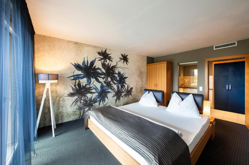 拉古多ALIA appartements & wellness的酒店客房设有一张床,墙上挂有绘画作品