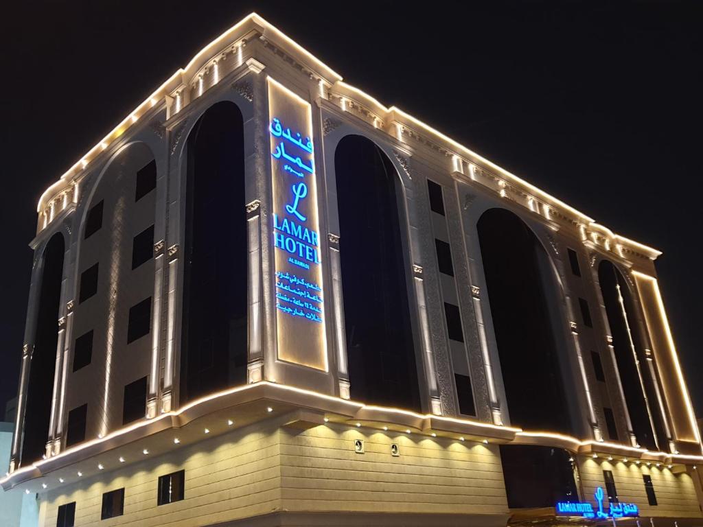 吉达Lamar Al Bawadi Hotel的一座大建筑,晚上有标志