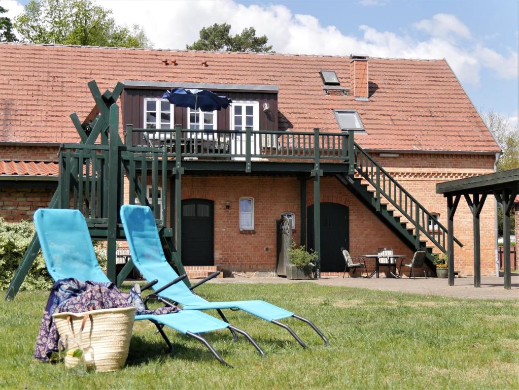 VipperowLindenhof Wohnung 3, Dachgeschoß的房子前面的草上两把蓝色的椅子