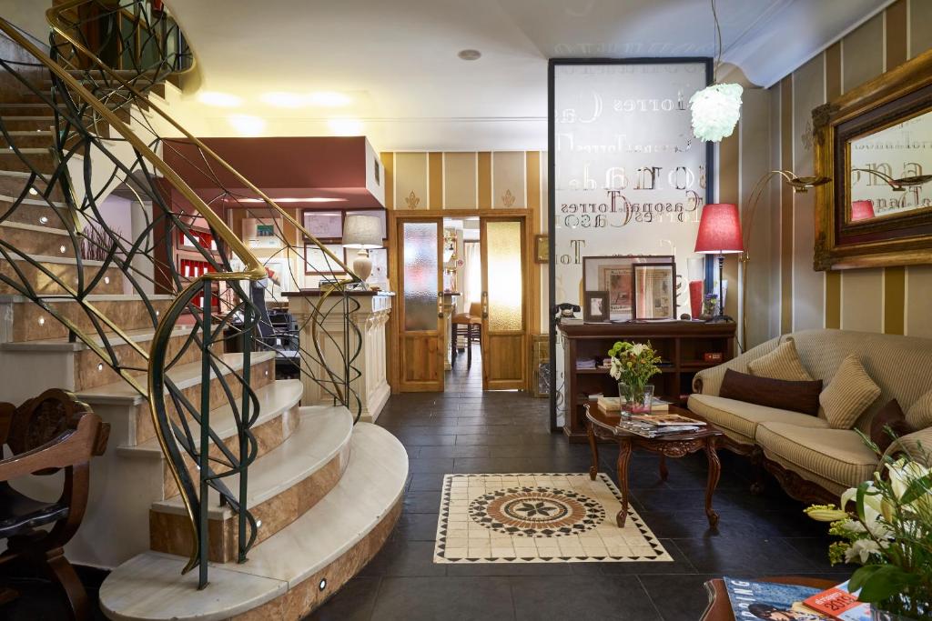 Mondéjar卡瑟纳托雷斯酒店的客厅设有螺旋楼梯和沙发
