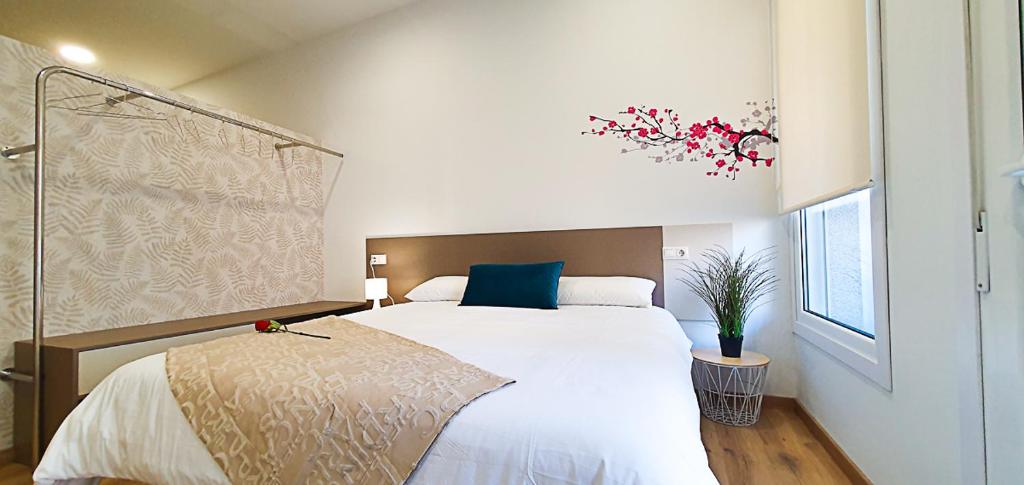 米拉多罗Apartamentos Antares 2的卧室配有一张白色大床和蓝色枕头