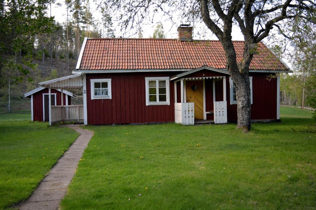 胡尔茨弗雷德Högerödja的院子里有树的红色房子