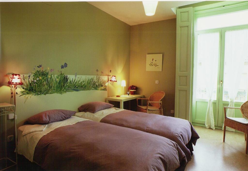 塞哥维亚福尔诺斯旅馆的一间卧室设有两张床、一张桌子和一个窗口