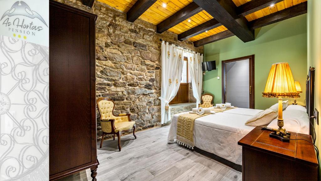 帕拉斯德丽Pensión As Hortas的一间卧室设有一张床和石墙